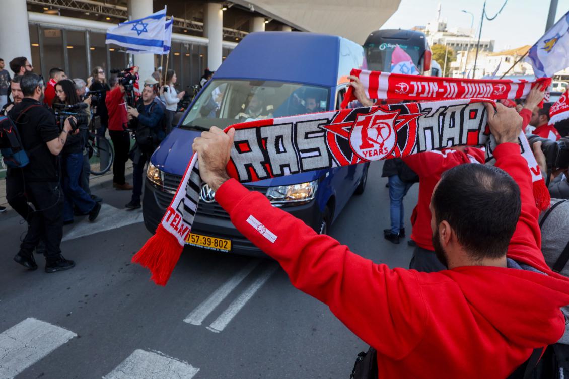 Hapoel Tel Aviv club supporters’ and football fans in general pay their respect as a van transports the body of late Israeli hostage Tsachi Idan, who was a Hapoel supporter, during a public memorial ceremony in his honor before his funeral, on Feb. 28, 2025, at Bloomfield Stadium with in Tel Aviv. (AFP)