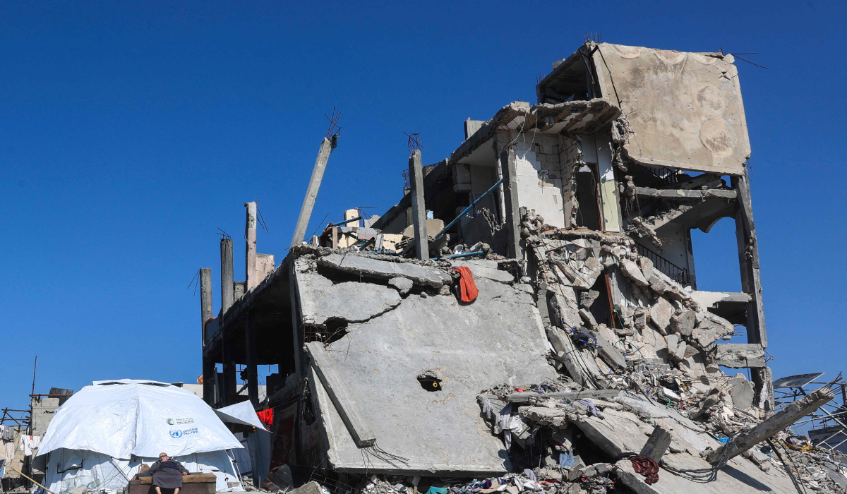 A Palestinian man sits outside his tent, next to a destroyed building in Jabalia in the northern Gaza Strip on February 27, 2025, amid the ongoing truce between Israel and Hamas. (AFP)