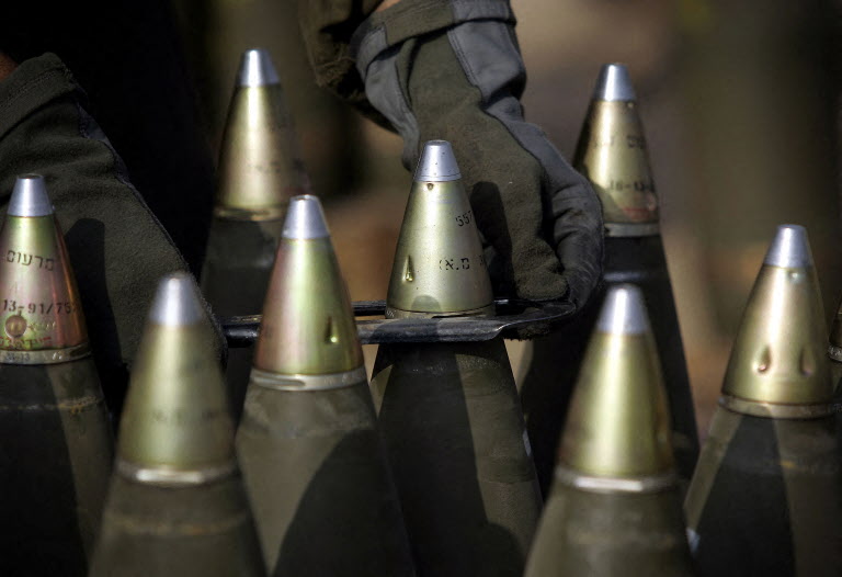 File photo An Israeli soldier tightens warheads onto 155 mm artillery shells as mobile artillery units prepare to fire on the Gaza Strip (AFP)