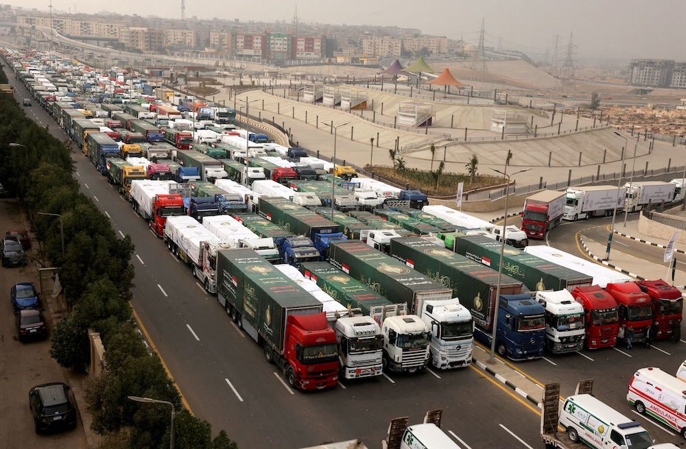 Trucks carrying Egyptian humanitarian aid wait to start moving to the Rafah border crossing to enter Gaza. (Reuters)