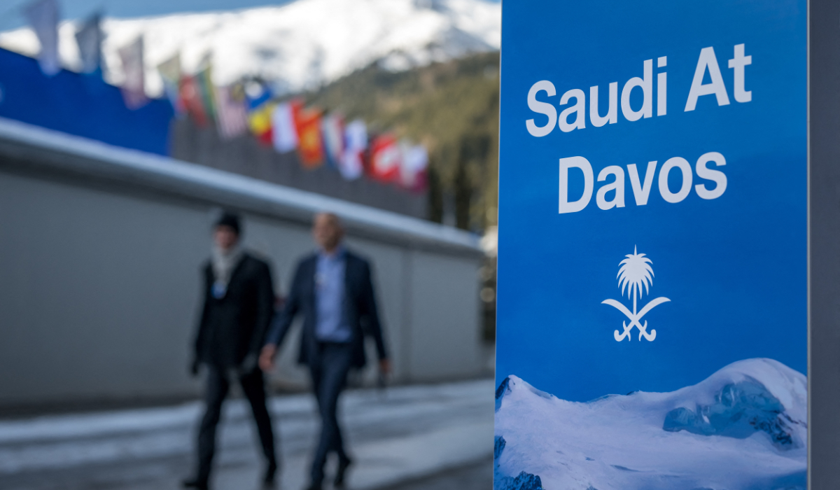 Attendees walk past a sign of the Saudi representation at the annual meeting of the World Economic Forum in Davos. (AFP)