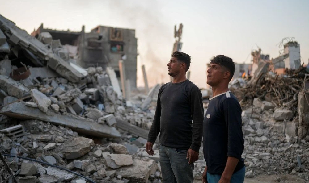 Mahmoud and Ibrahim Al-Atout look at the rubble of their destroyed house, Jabalia, northern Gaza Strip, Jan. 29, 2025. (Reuters)