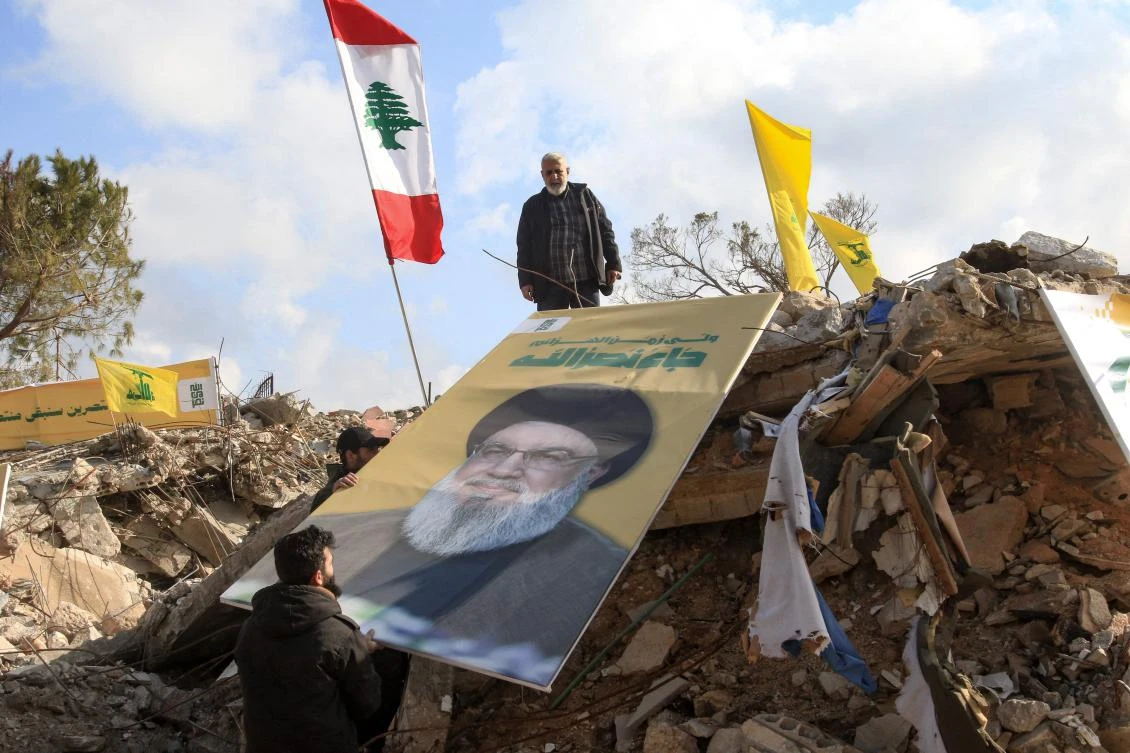 People place a picture of slain Hezbollah leader Hassan Nasrallah over the rubble of the shrine of Shamoun al-Safa in southern Lebanon's Tyre governorate, Jan. 31 (AFP)