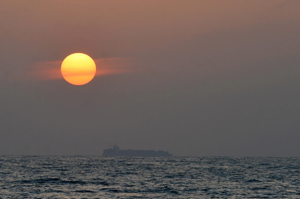 A container ship navigates on the waters of the Indian Ocean at sunset off the coast of Colombo, Sept. 4, 2018. (AFP)
