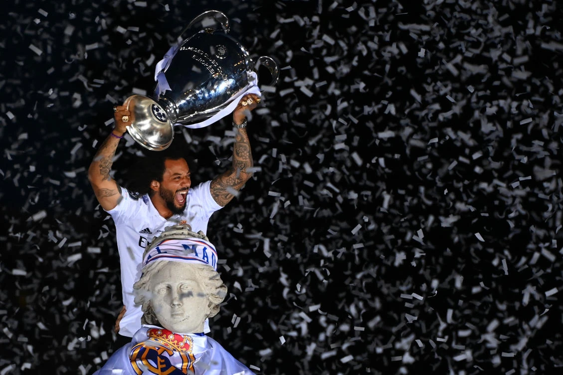 Real Madrid’s Brazilian defender Marcelo lifts their trophy ontop of the statue of Greek goddess Cybele on May 29, 2022 at the Cibeles square in Madrid, a day after beating Liverpool in the UEFA Champions League final in Paris. (AFP/File)