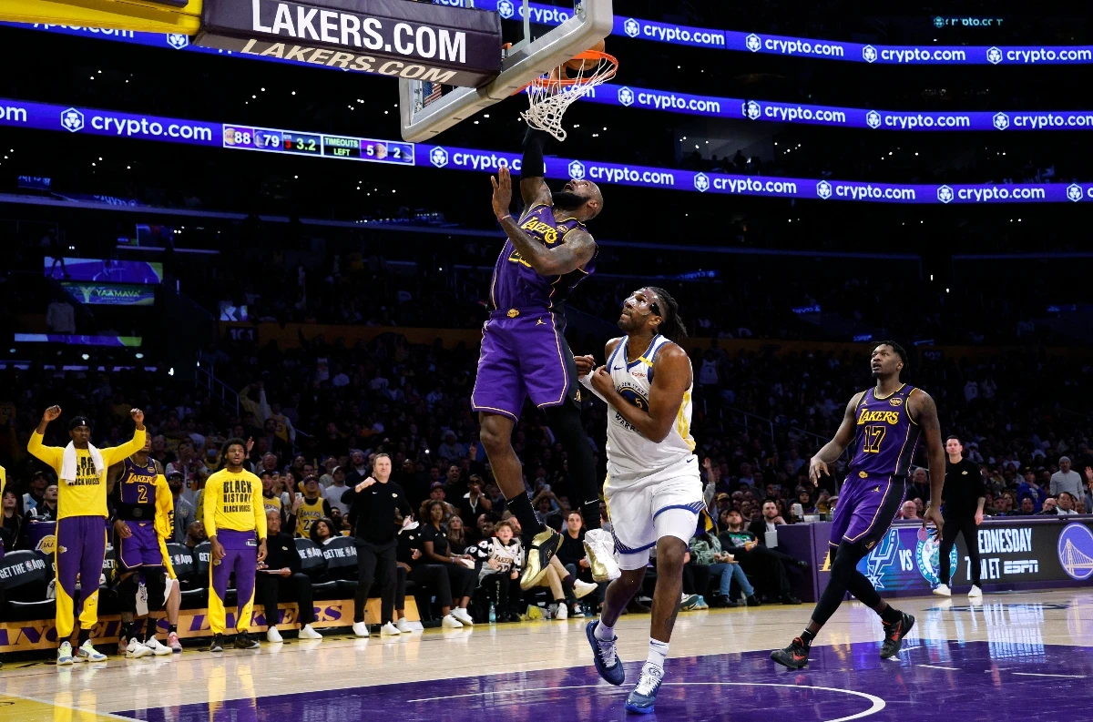 Los Angeles Lakers forward LeBron James scores a basket against Golden State Warriors forward Kevon Looney during the second half of an NBA basketball game Thursday in Los Angeles. (AP)