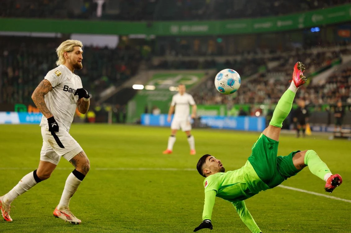 Wolfsburg’s Algerian forward Mohammed Amoura makes an overhead kick past Bayer Leverkusen’s German midfielder Robert Andrich during their Bundesliga match in Wolfsburg, northern Germany on Feb. 8, 2025. (AFP)