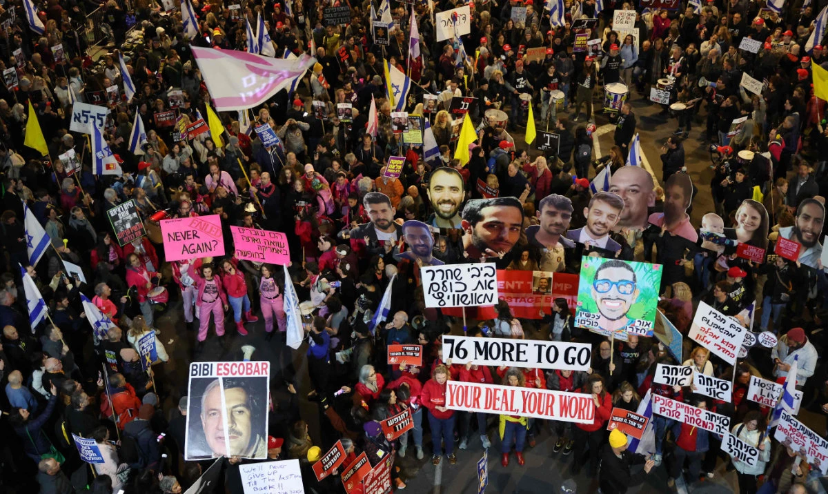 Demonstrators raise placards and chant slogans during a protest calling for the release of hostages held captive in Gaza since the October 7, 2024 attack by Palestinian militants, in front of the Israeli Defense Ministry in Tel Aviv on February 8, 2025. (AFP)