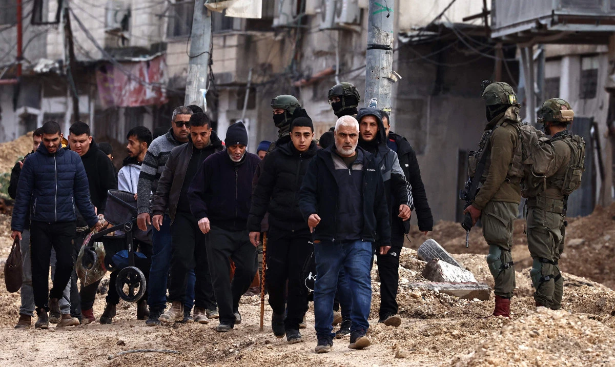 Israeli soldiers keep watch as Palestinians leave their homes for safety during a raid by the army in the Nur Shams refugee camp near Tulkarem in the occupied West Bank on February 10, 2025. (AFP)