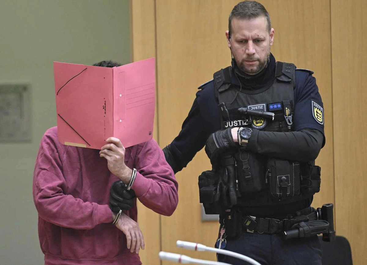 Defendant (L) arrives in the courtroom of the Higher Regional Court in Stuttgart-Stammheim, southern Germany, on February 13, 2025, before the start of his trial. (AFP)