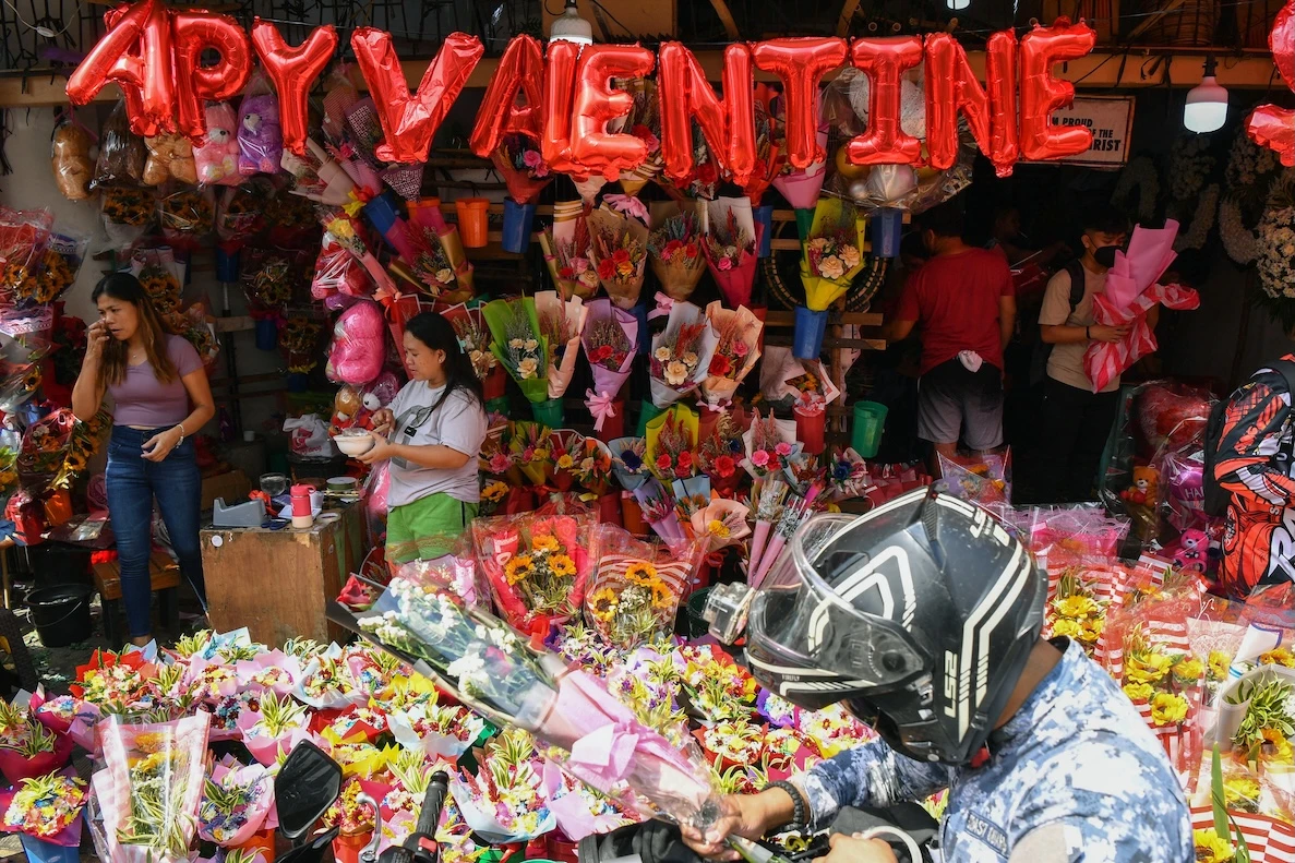 People buy bouquets on Valentine's Day at a flower market in Manila on Feb. 14, 2023. (AFP)