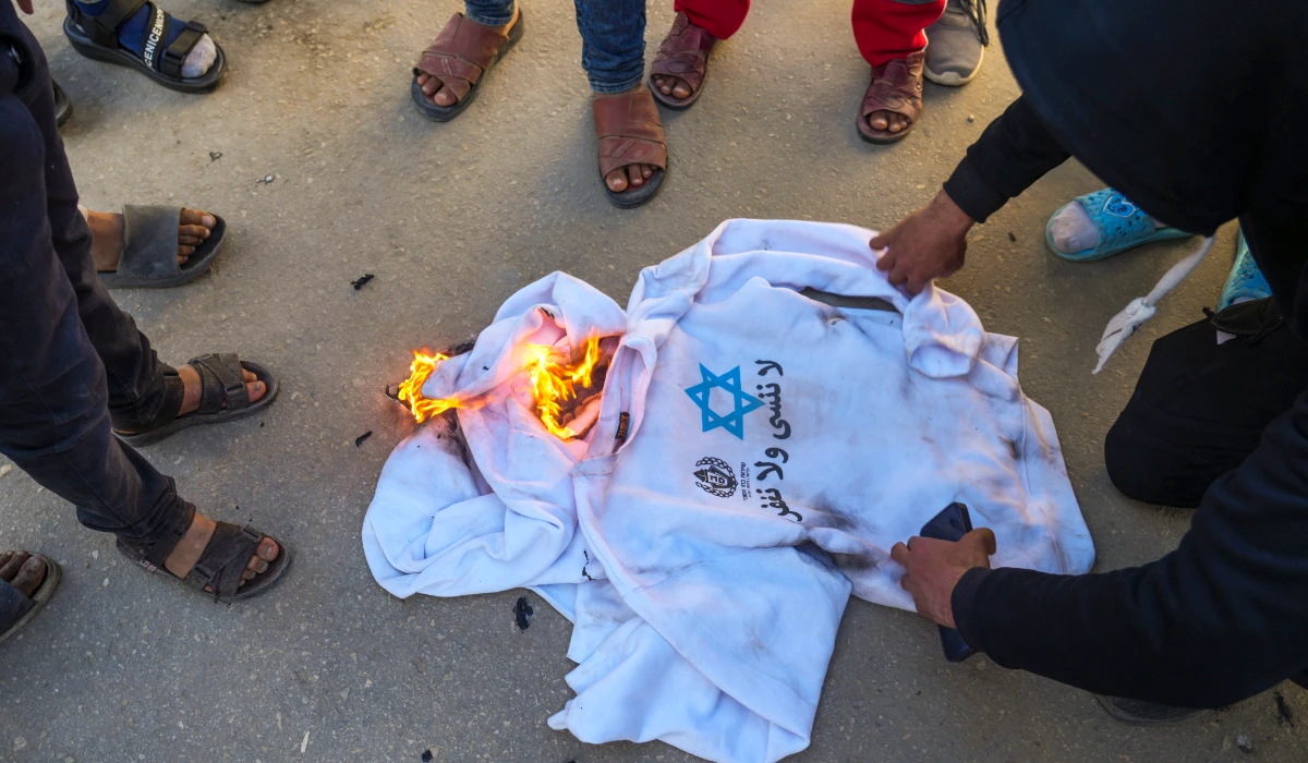 A crowd burns the shirts worn by freed Palestinian prisoners in Khan Younis, Gaza Strip, Saturday, Feb. 15, 2025, as they arrive in Gaza after being released from an Israeli prison following a ceasefire agreement between Hamas and Israel. (AP)