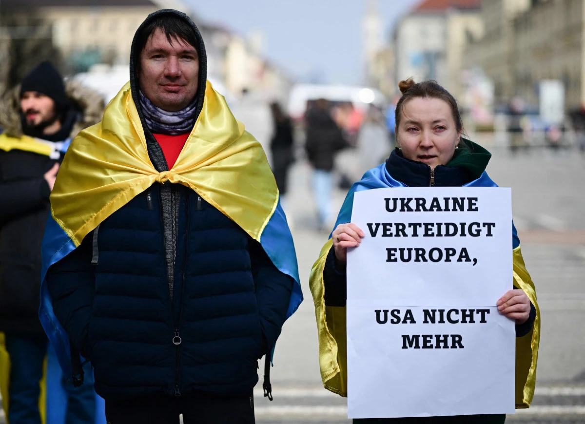 A protester holds a sign reading "Ukraine defends Europe, USA doesn't anymore" during a demonstration supporting Ukraine in Munich on February 15, 2025. (AFP)
