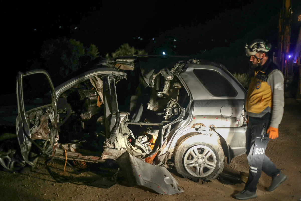 This photo taken early on January 31, 2025, shows a Syrian White Helmet rescuer checking the wreckage of a car at the site of a US coalition airstrike targeting a leader of Syria's Al-Qaeda affiliate Hurras al-Din, on a highway near the village of Batabo in northwest Syria. (AFP)