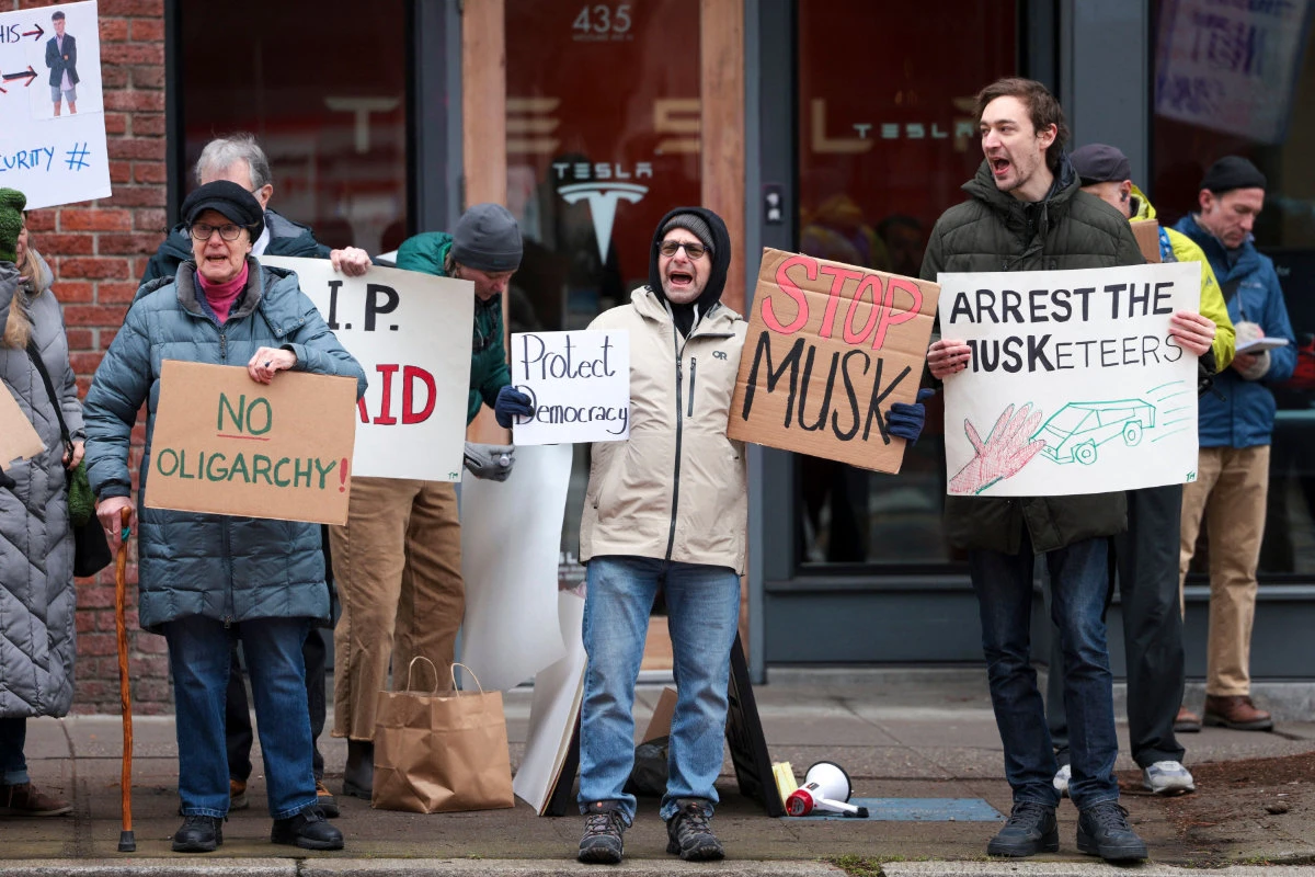 People participate in a "TeslaTakedown" protest against Elon Musk in Seattle, Washington, on February 15, 2025. (AFP)