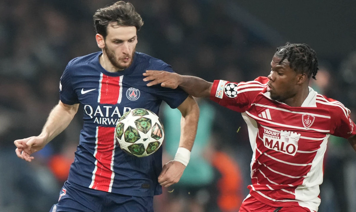 PSG's Khvicha Kvaratskhelia, left, is challenged by Brest's Luck Zogbe during the Champions League playoff second leg soccer match between Paris Saint-Germain and Brest at the Parc des Princes in Paris, Wednesday, Feb. 19, 2025. (AP)