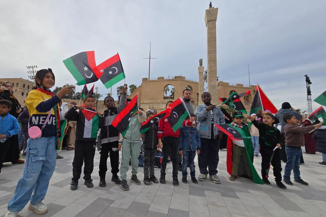 Libyan children wave the national flag in the Martyrs’ Square in Tripoli on Feb. 17, 2025., during a gathering to commemorate the 14th anniversary of the uprising that toppled longtime strongman Muammar Qaddafi. (AFP)