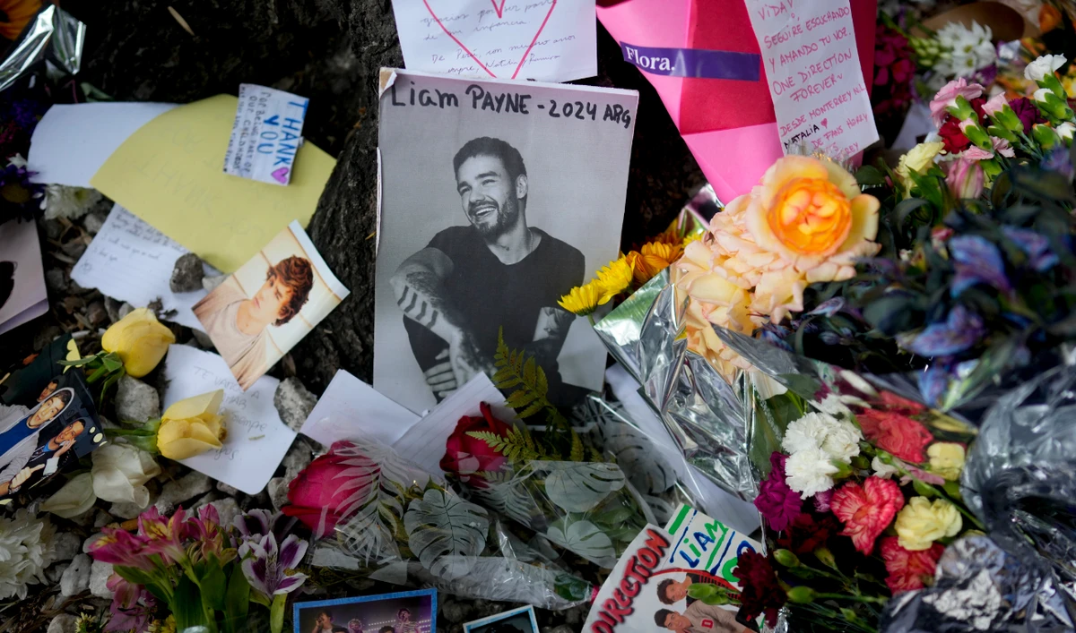 A picture of former One Direction singer Liam Payne is surrounded with flowers and candles as part of a makeshift memorial outside the hotel where he fell from a balcony to his death, in Buenos Aires, Argentina, Oct. 17, 2024. (AP)