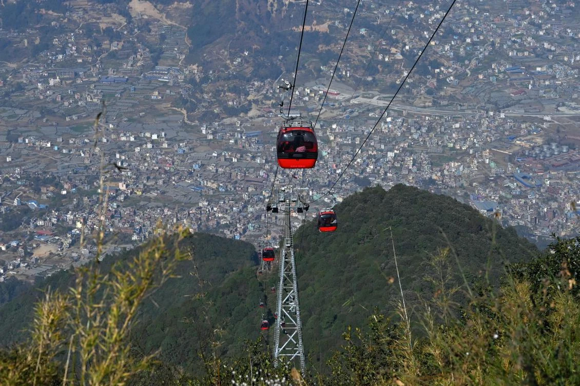 Above, people ride cable cars over the Chandragiri hilltop, on outskirts of Katmandu. (AFP)