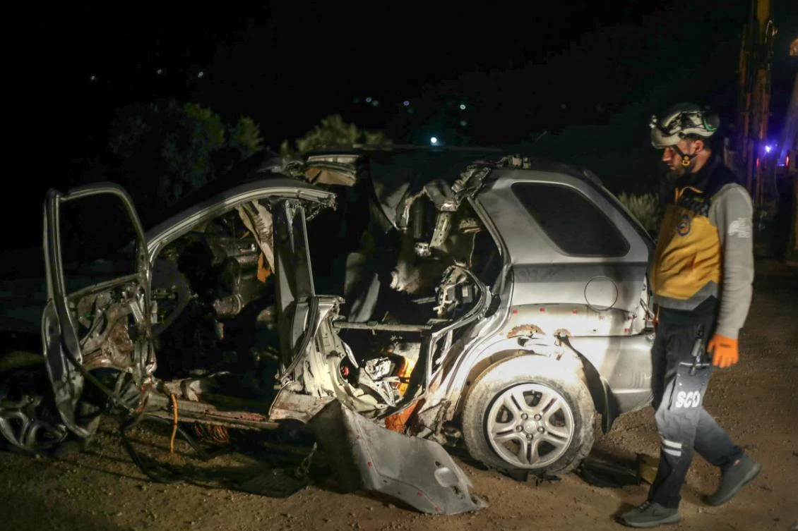 A Syrian White Helmet rescuer checks the wreckage of a car at the site of a US coalition airstrike targeting a leader of Syria's Al-Qaeda affiliate Hurras al-Din, on a highway near the village of Batabo in northwest Syria, early on January 31, 2025. (AFP)