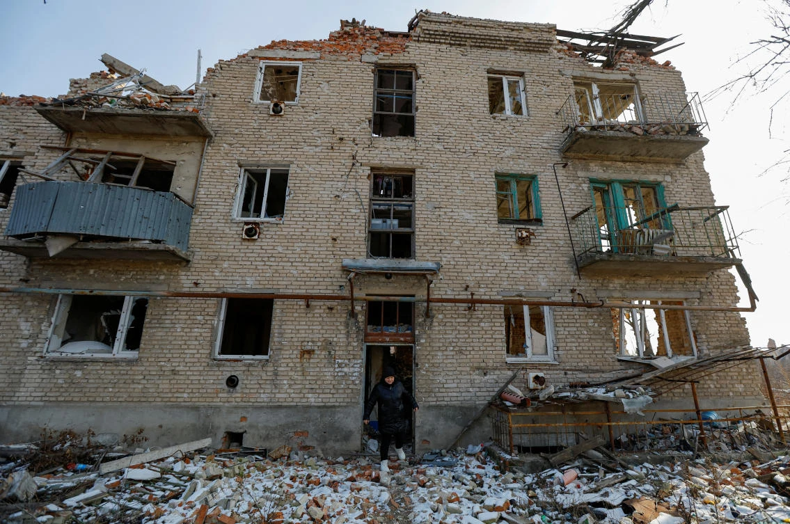 Resident Maria Seryogova, 49, walks out of a building as she comes to visit her apartment destroyed in the course of Russia-Ukraine conflict in Pisky (Peski), a Russian controlled region of Ukraine, Feb. 14, 2025. (Reuters)