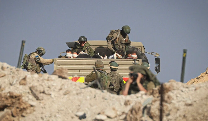 Israeli soldiers detain blindfolded Palestinian men in a military truck in the Zeitoun district of the southern part of the Gaza Strip on November 19, 2023. (AFP file photo)