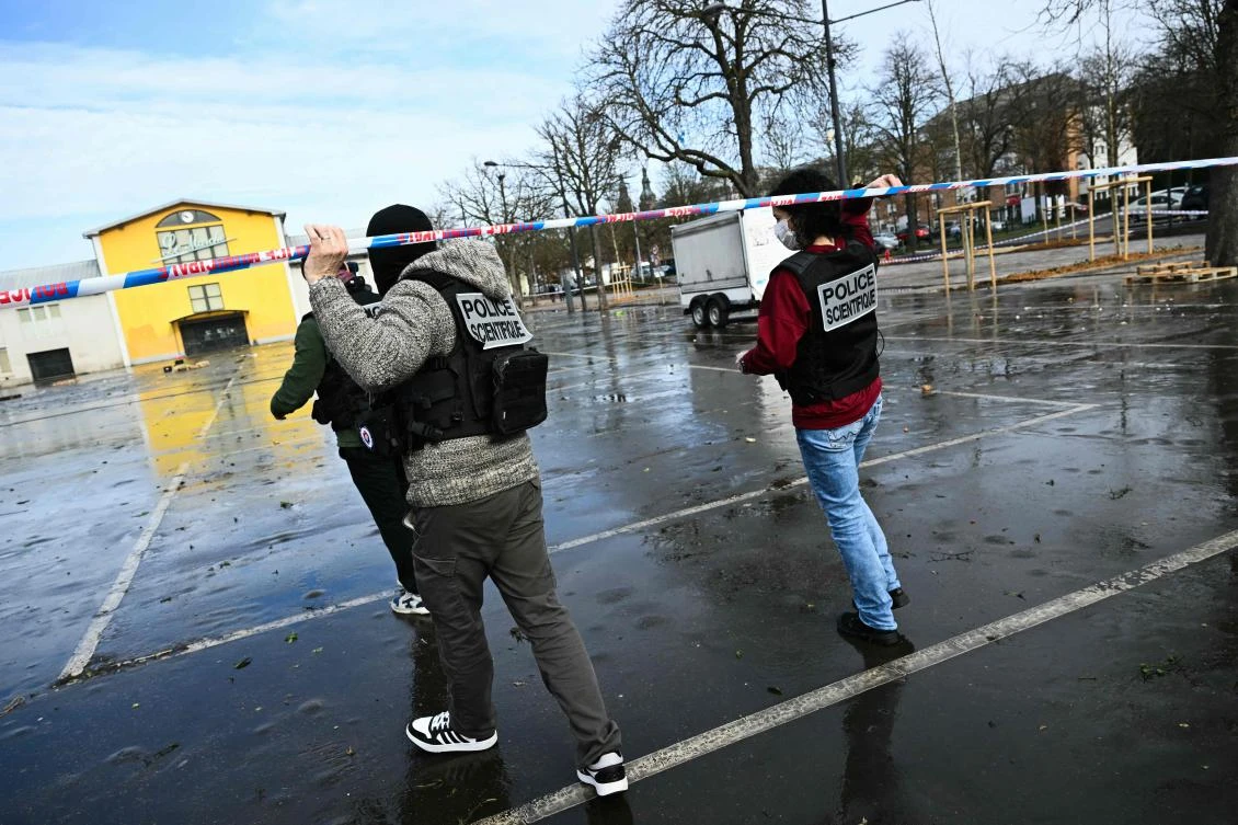 French forensic police walk under police caution tape as they arrive to collect evidence at the site of a bladed weapon attack where a man is suspected of killing one person and wounding two municipal police officers in Mulhouse, eastern France on February 23, 2025. (AFP)