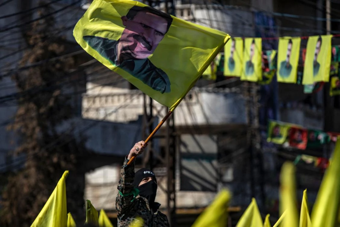 A protester waves a flag bearing a portrait of Abdullah Ocalan, the leader of the Kurdistan Worker's Party (PKK) jailed in Turkey since 1999, during a demonstration calling for his release in the Kurdish-majority city of Qamishli in northeastern Syria on February 15, 2025. (AFP)