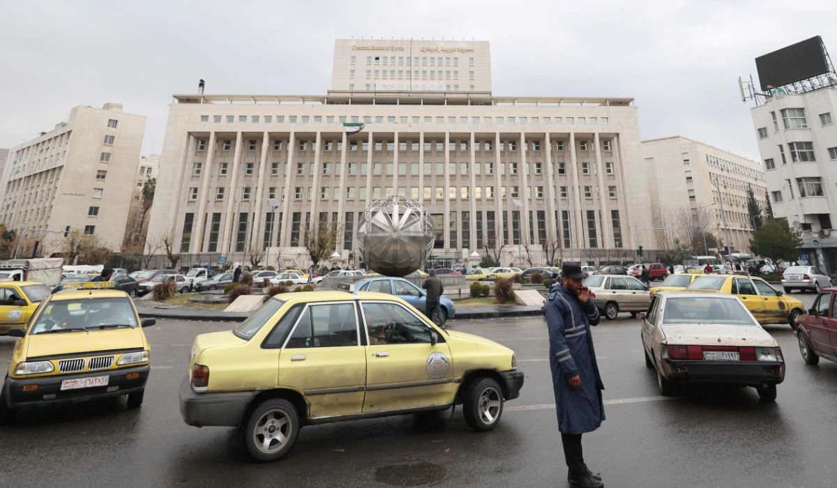 A Syrian officer directs traffic past the Central Bank building in Sabaa Bahrat Square in the capital Damascus on December 29, 2024. (AFP)