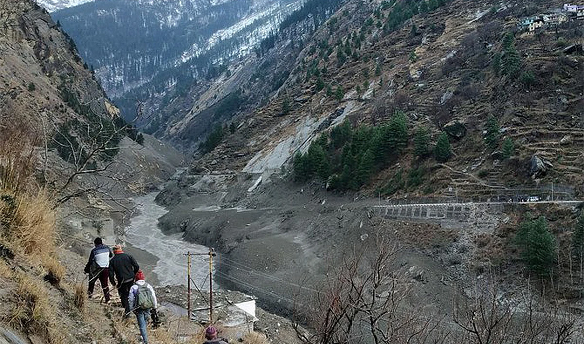 People walk past a destroyed dam after a Himalayan glacier broke and crashed into the dam at Raini Chak Lata village in Chamoli district, northern state of Uttarakhand, India, February 7, 2021. (Reuters/File)
