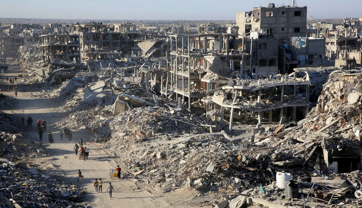 Palestinians walk past the rubble of destroyed buildings, following the ceasefire, Rafah, Gaza, Jan. 20, 2025. (Reuters)