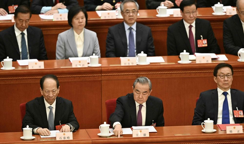 China’s FM Wang Yi, center, votes during the closing session of the National People’s Congress, Beijing, Mar. 11, 2025. (AFP)
