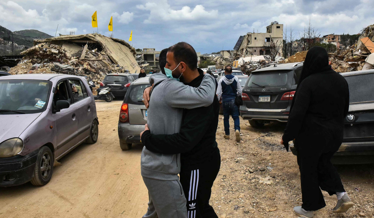 People embrace as they return to their homes in the southern Lebanese village of Kfar Kila near the border with Israel on February 19, 2025. (AFP)