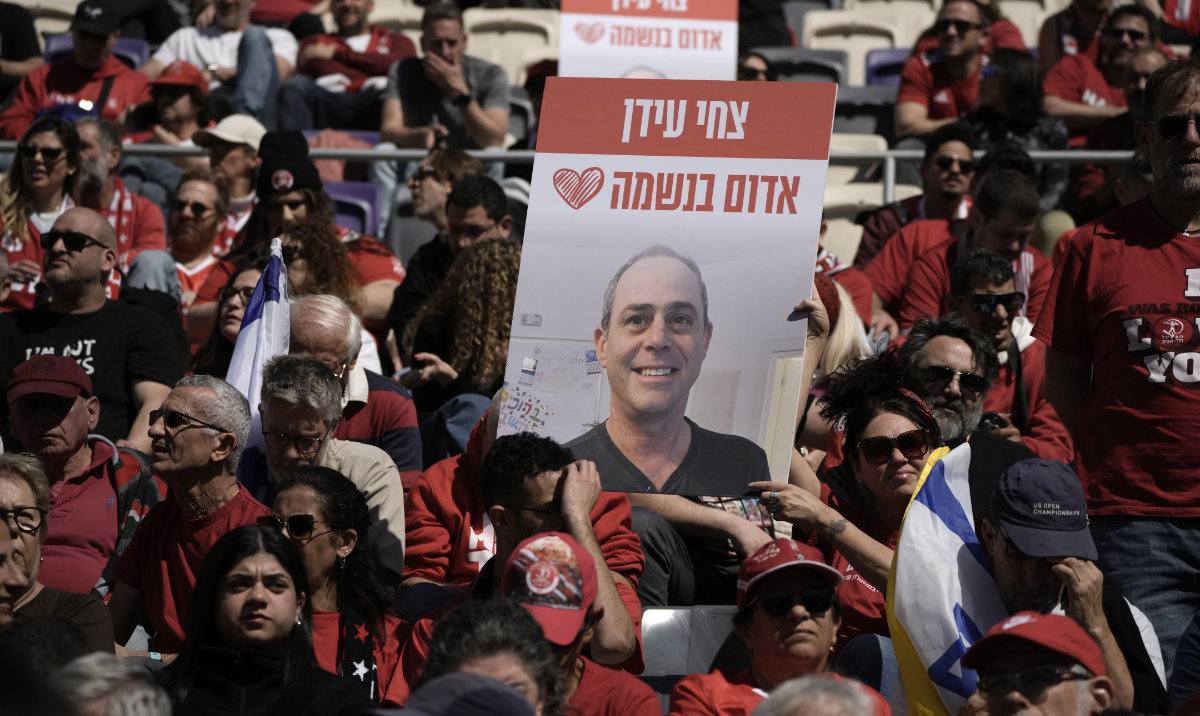People attend a public memorial ceremony for slain hostage Tsachi Idan, a fan of Hapoel Tel Aviv F.C., who was killed in Hamas captivity in the Gaza Strip, at Bloomfield Stadium in Tel Aviv, Israel, Friday, Feb. 28, 2025. Hebrew: "Tsachi Idan - red in the soul." (AP)