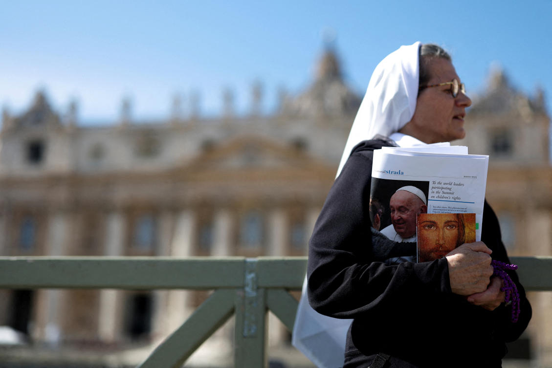 A nun holds a newspaper with an image of Pope Francis in St. Peter's Square, as Pope Francis continues hospitalization, at the Vatican, March 2, 2025. (Reuters)