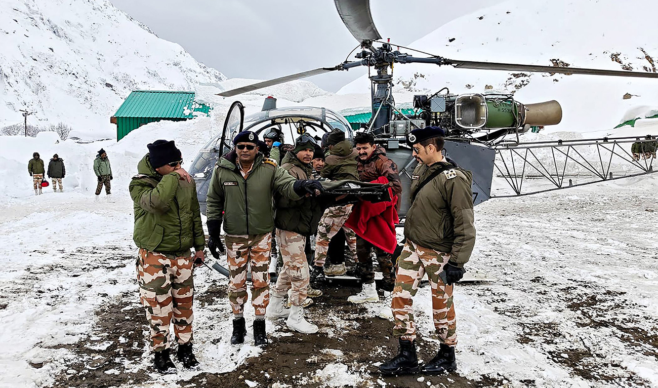In this handout photograph taken on March 1, 2025, and released by the Department of Information and Public Relations (DIPR) Uttarakhand, security personnel carry a victim onto a helicopter during a rescue operation, in the Chamoli district of India’s Uttarakhand state. (Photo Courtesy: AFP via DIPR)