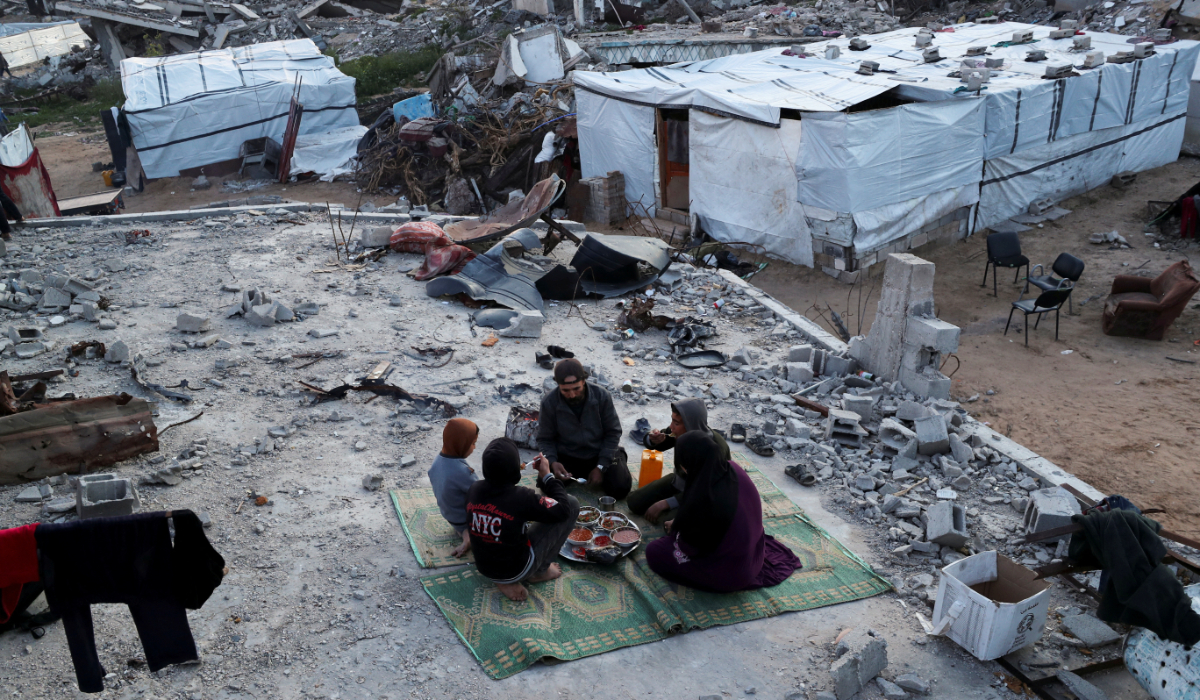 A Palestinian family break the fast by eating the Iftar meals during the holy month of Ramadan, on the rubble of their house at Jabalia refugee camp in northern Gaza Strip, March 2, 2025. (REUTERS)