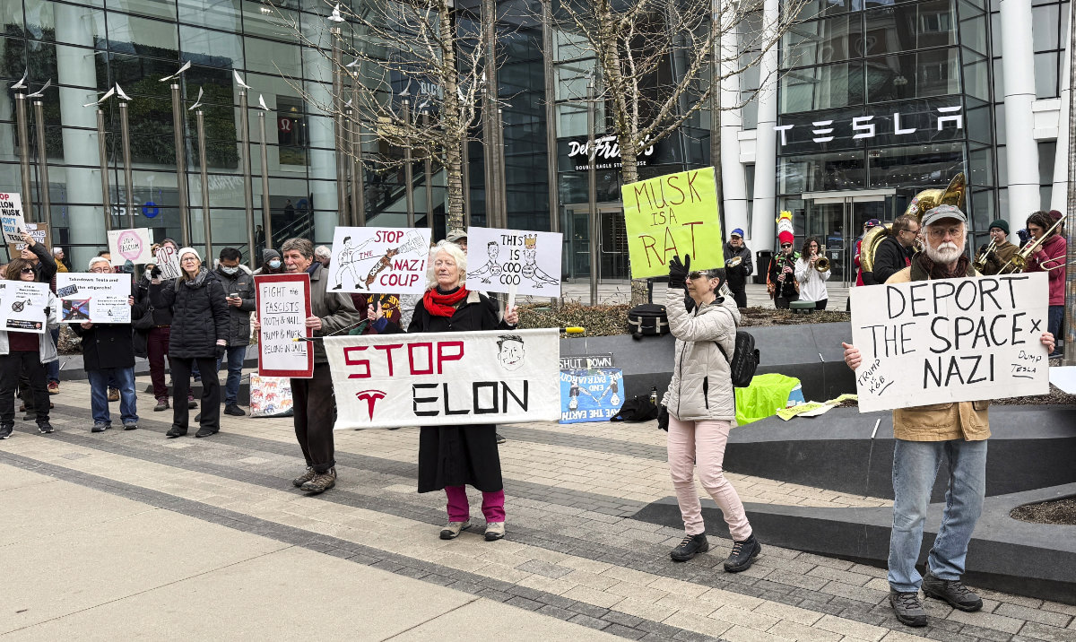 Protesters rally outside of a Tesla store in Boston, Saturday, March 1, 2025, against the company's CEO, Elon Musk, who is leading an effort to cut government jobs on behalf of President Donald Trump. (AP)