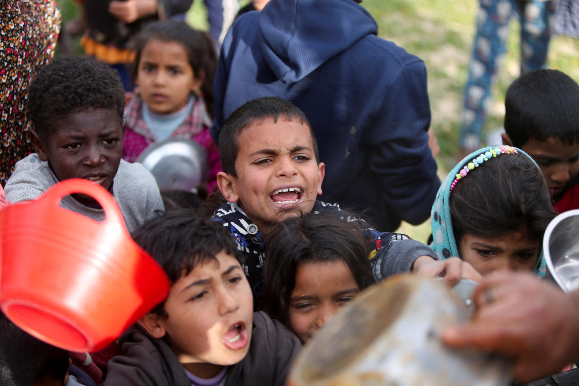 Palestinian children gather to receive food cooked by a charity kitchen, during the Muslim holy month of Ramadan, in Khan Younis, in the southern Gaza Strip, March 3, 2025. (Reuters)