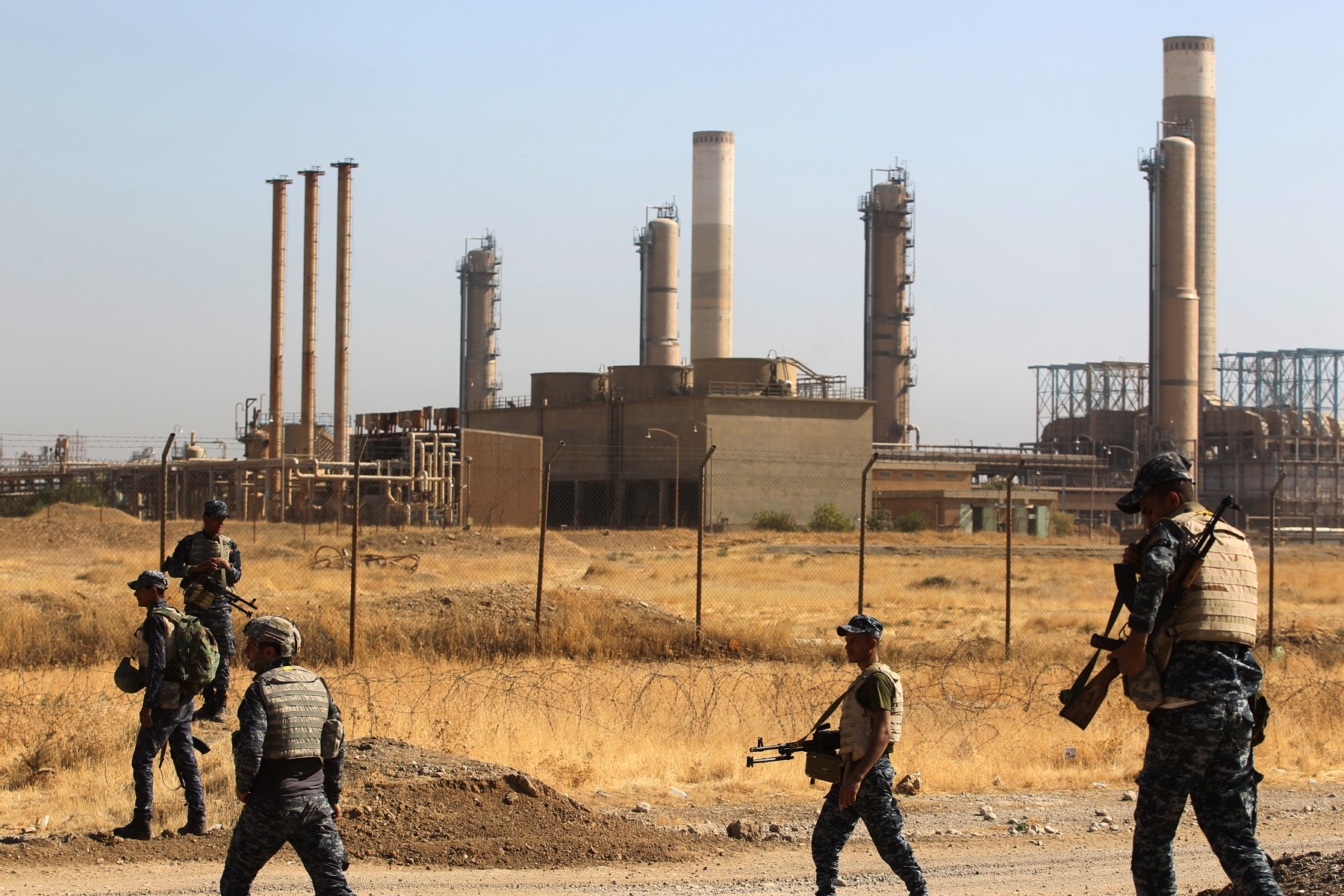 Iraqi forces walk past an oil production plant as they head towards the city of Kirkuk during an operation against Kurdish fighters on October 16, 2017. (File/AFP)