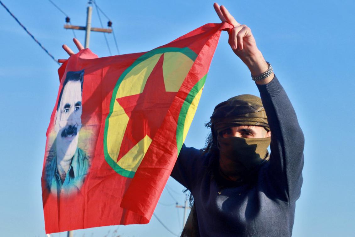 An Iraqi Kurdish woman waves a flag bearing the portrait of the founder of the Kurdistan Worker's Party (PKK) Abdullah Ocalan as people gather at Freedom Park to listen to an audio message by the jailed leader in Sulaimaniyah, in Iraq's autonomous Kurdistan region on February 27, 2025. (AFP)