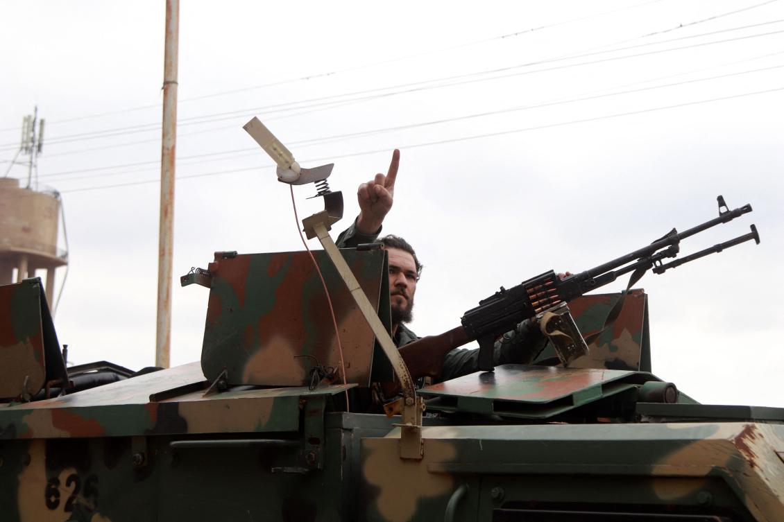 A member of Syria's new authorities security forces gestures from an armoured vehicle in Sanamayn, in the southern province of Daraa, during a reported large scale military campaign on March 5, 2025. (AFP)