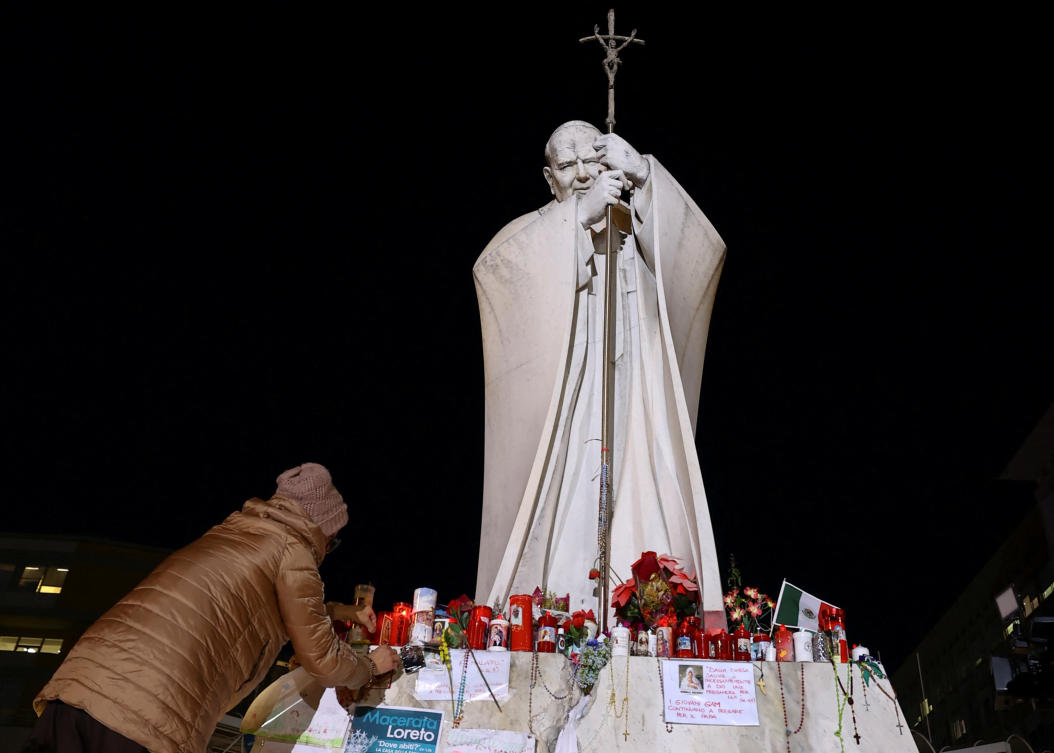Candles are placed at the statue of late Pope John Paul II outside Gemelli Hospital where Pope Francis is admitted for treatment, in Rome, Mar. 6, 2025. (Reuters)