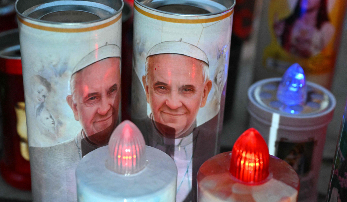 Candles with a image of Pope Francis are laid at the statue of John Paul II outside the Gemelli University Hospital where Pope Francis is hospitalized with pneumonia, in Rome on March 7, 2025. (AFP)