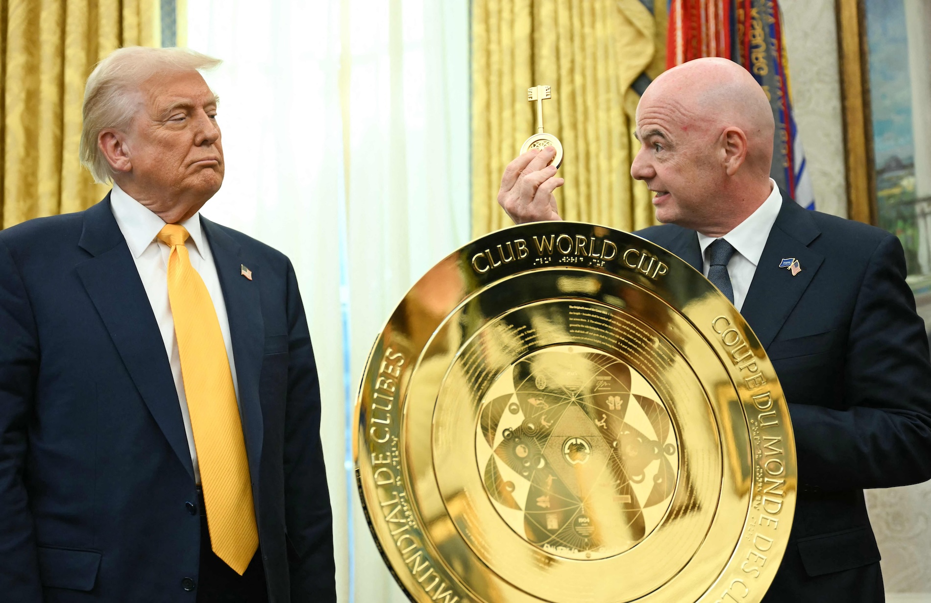 US President Donald Trump watches as FIFA president Gianni Infantino presents him with the key to unlock the new FIFA Club World Cup trophy in the Oval office of the White House, in Washington, DC, on March 7, 2025. ( AFP)
