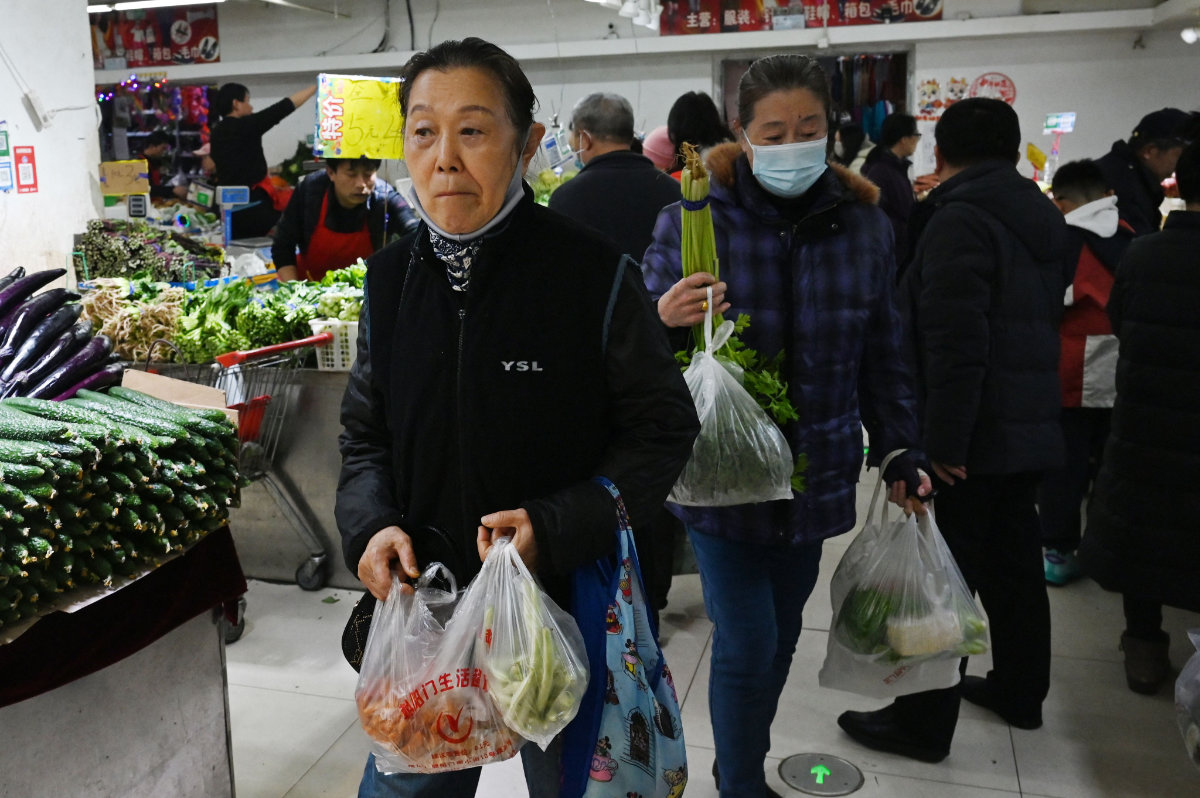 People shop for vegetables in a market in Beijing on March 9, 2025. Consumer prices in China fell last month, with authorities struggling to kickstart spending and trade headwinds intensifying as US tariffs kick in under Donald Trump. (AFP)
