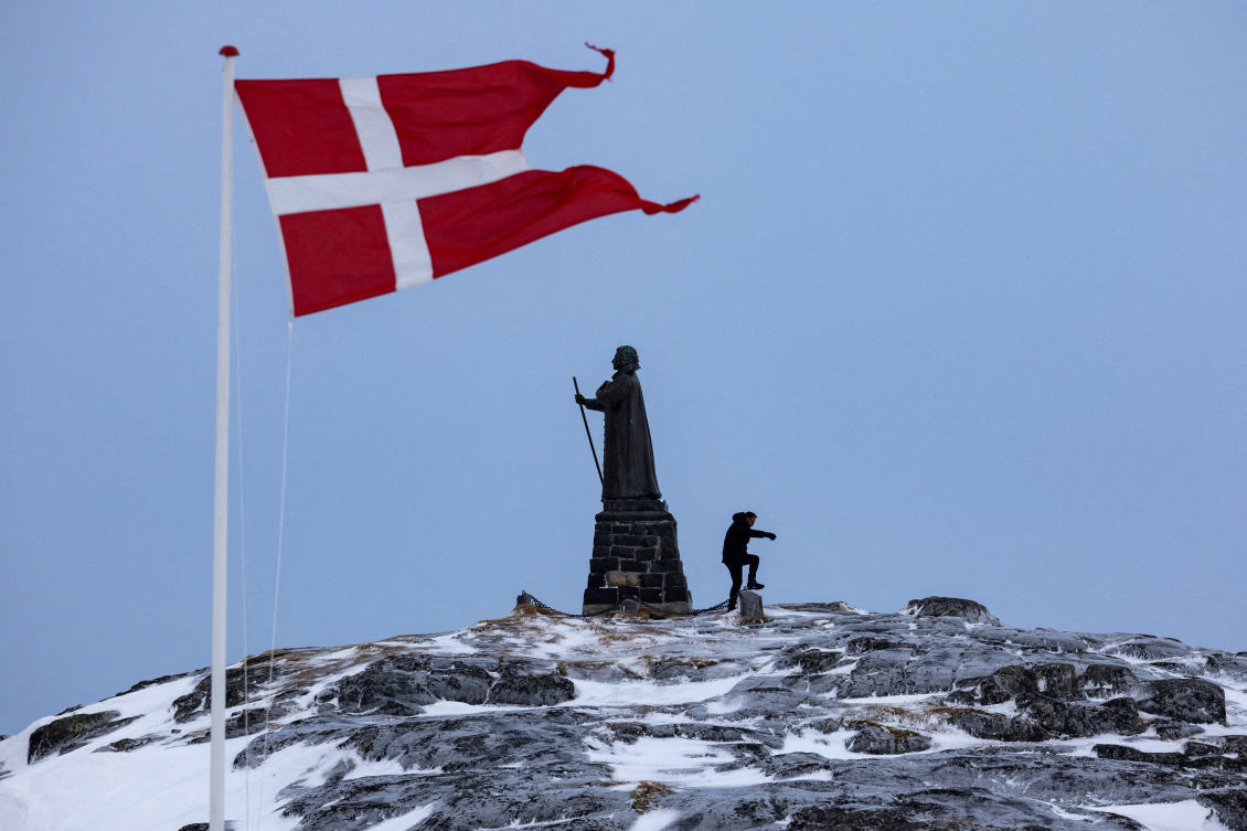 A man walks as Danish flag flutters next to Hans Egede Statue ahead of a March 11 general election in Nuuk, Greenland, March 9, 2025. (Reuters)