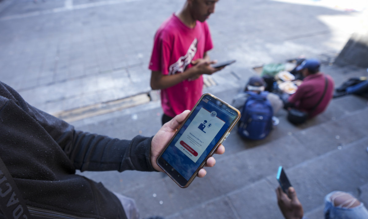 Venezuelan migrant Yender Romero shows the US Customs and Border Protection (CBP) One app on his cell phone, which he said he used to apply for asylum in the US and is waiting on an answer, at a migrant tent camp outside La Soledad church in Mexico City, Monday, Jan. 20, 2025, the inauguration day of US President Donald Trump. (AP)