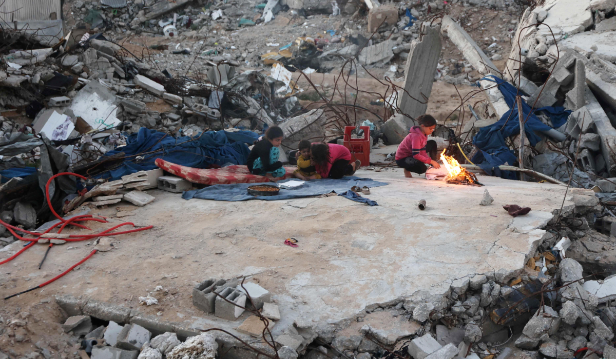 Palestinian children sit on the rubble of their house as they wait to break their fast in Jabalia in the northern Gaza Strip on March 10, 2025, during the Muslim holy fasting month of Ramadan. (AFP)