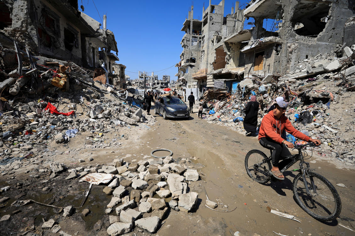 Palestinians pass by the rubble of destroyed houses, in Gaza City, Mar. 11, 2025. (Reuters)